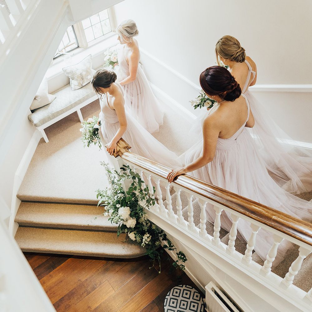 Bridal party walking down the stairs in TH&TH Tulle, soft pink bridesmaid dresses 