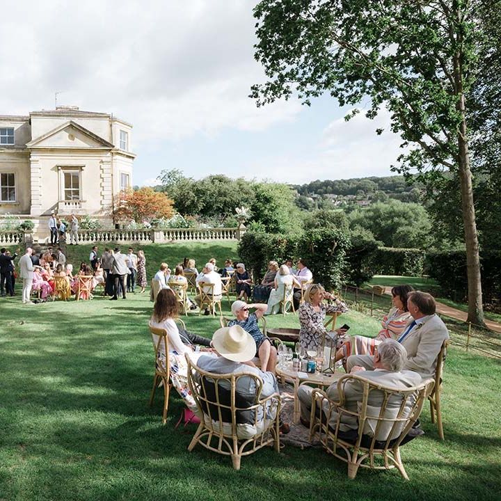 Country style outdoor English wedding at Georgian house in Bath with wedding guests mingling outside tipi reception