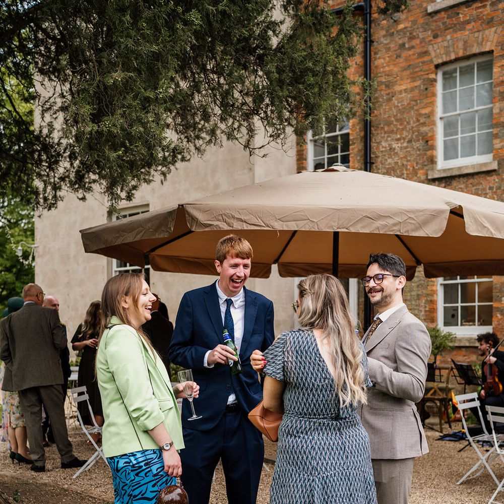 Wedding guests socialise around at the wedding 