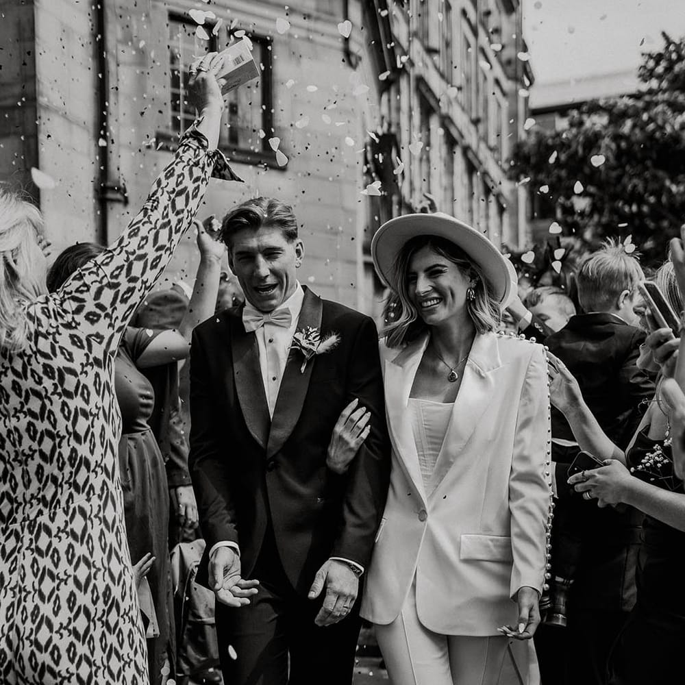 Bride and groom walk through heart shaped confetti after their town hall wedding 