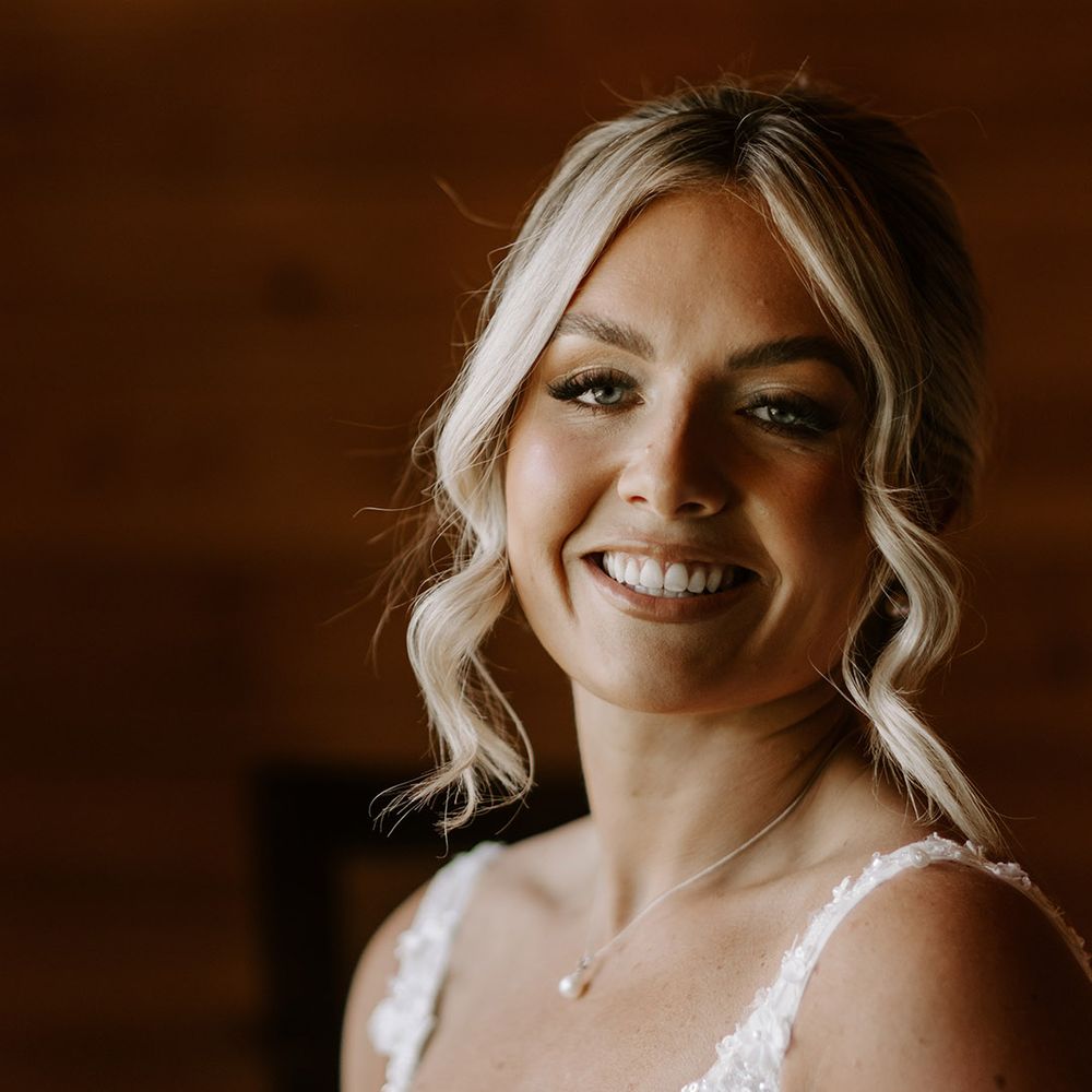 Blonde bride with her in an updo with soft glowy bridal makeup wearing pearl jewellery 