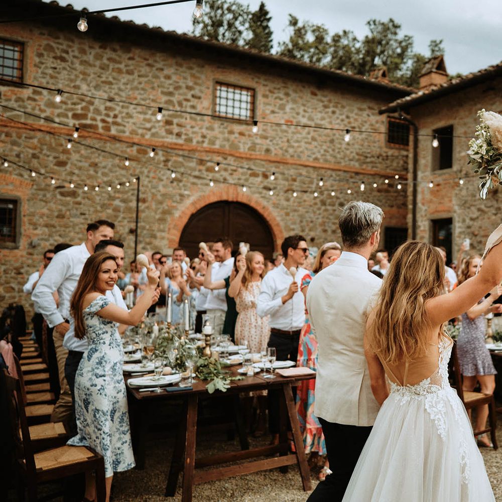 Couple wedding reception entrance showing brides backless wedding dress, pampas grass and eucalyptus bridal bouquet and Italian villa at destination wedding