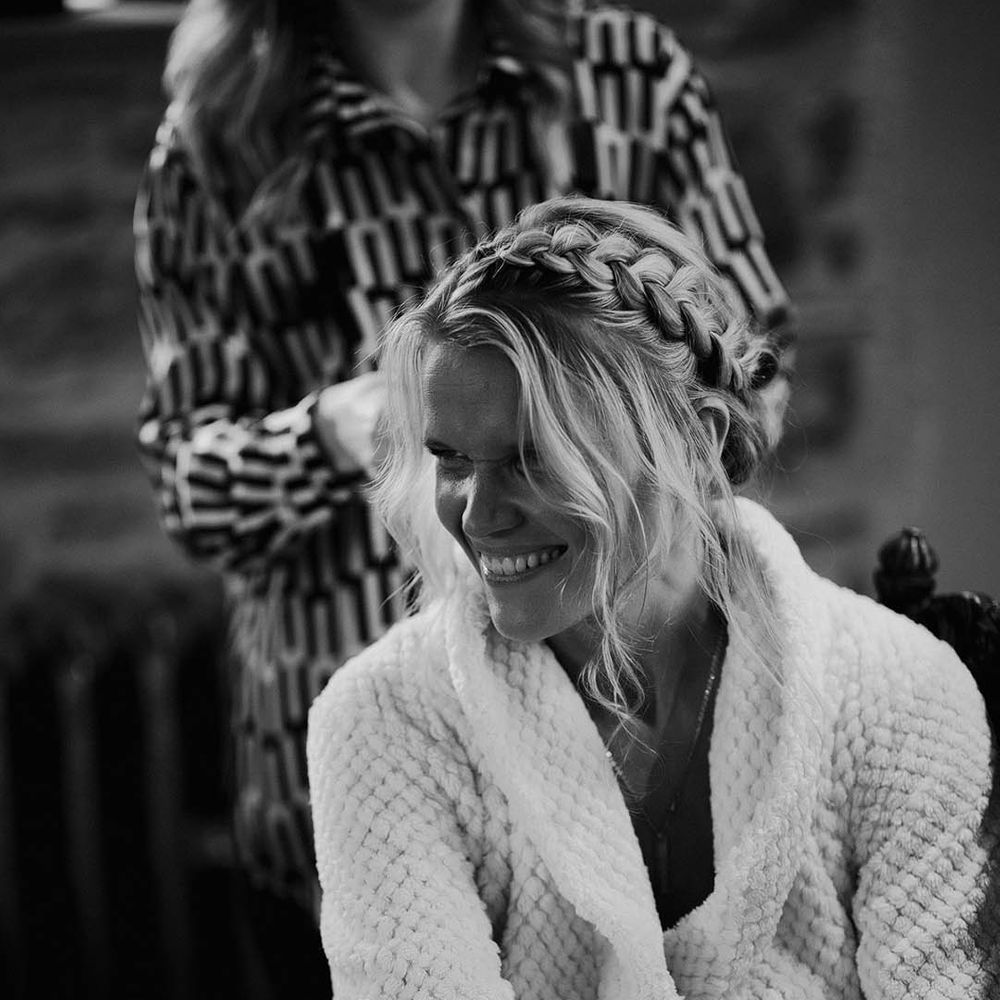 Bride in waffle white robe with braided crown hairstyle 