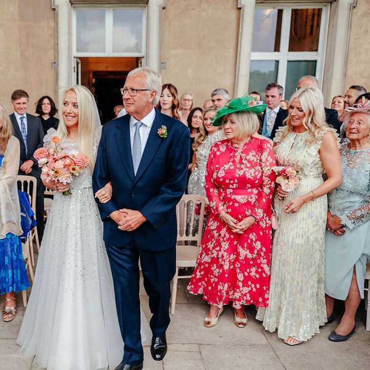 Father of the bride walks the bride down the aisle 