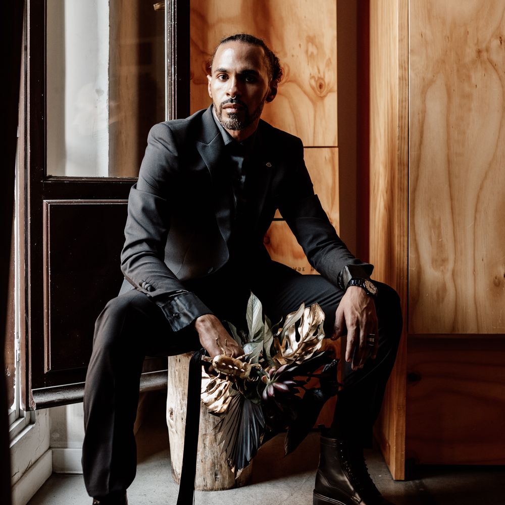 Groom sits with bouquet with accent gold colour 