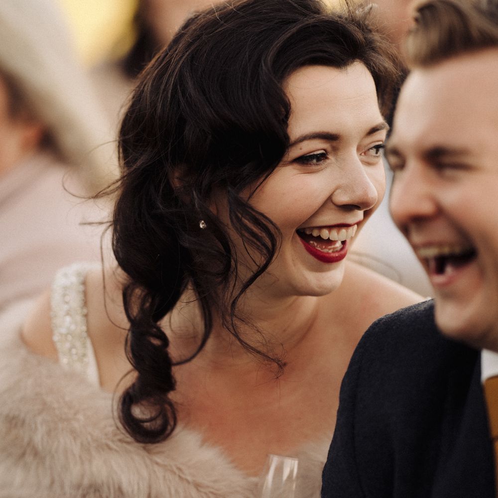 Bride & groom laugh during wedding reception speeches