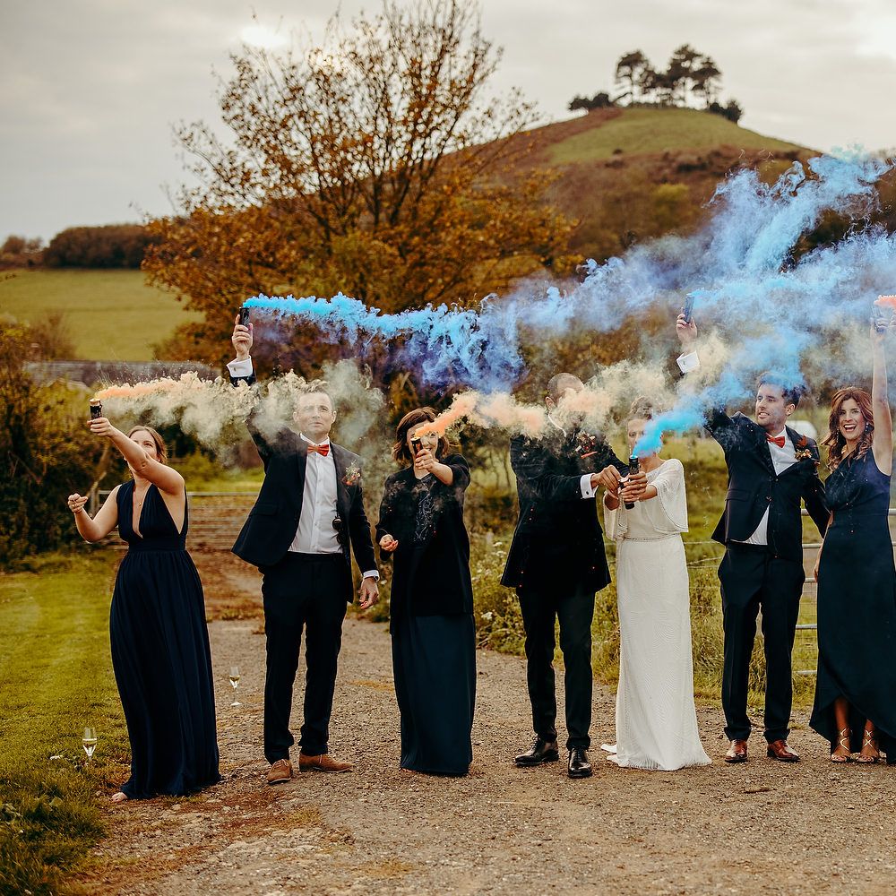 Wedding party with blue smoke bombs outdoors 