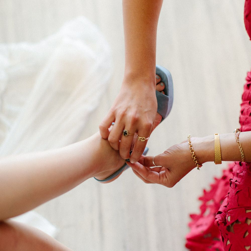 The bride having her blue Prada wedding heels fitted