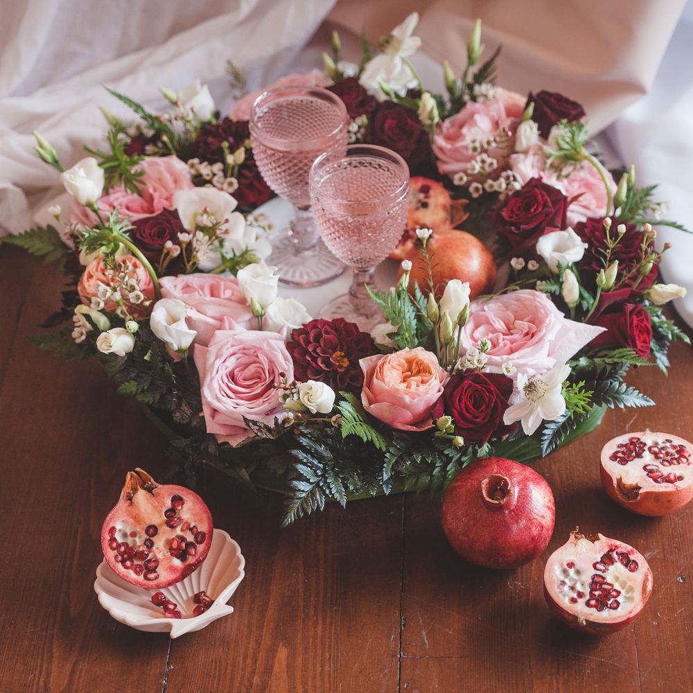 Floral decorated tray with pink, red and white roses and dahlias with green foliage and coloured glass goblets 