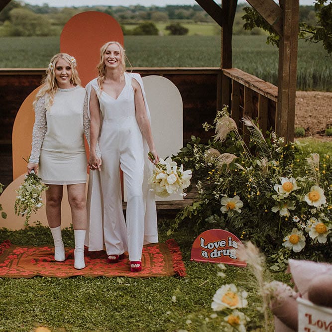 Outdoor LGBTQI+ wedding at Huntsmill Farm with retro signs, wool rugs and wildflower decor 