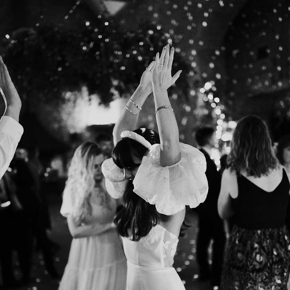 Bride dances during wedding reception party in black & white image
