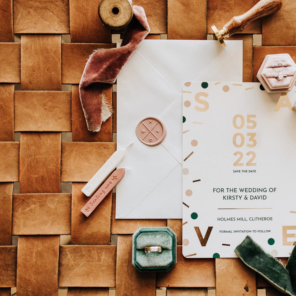 White wedding invitations with confetti decor, velvet wedding ring boxes and wax stamp 