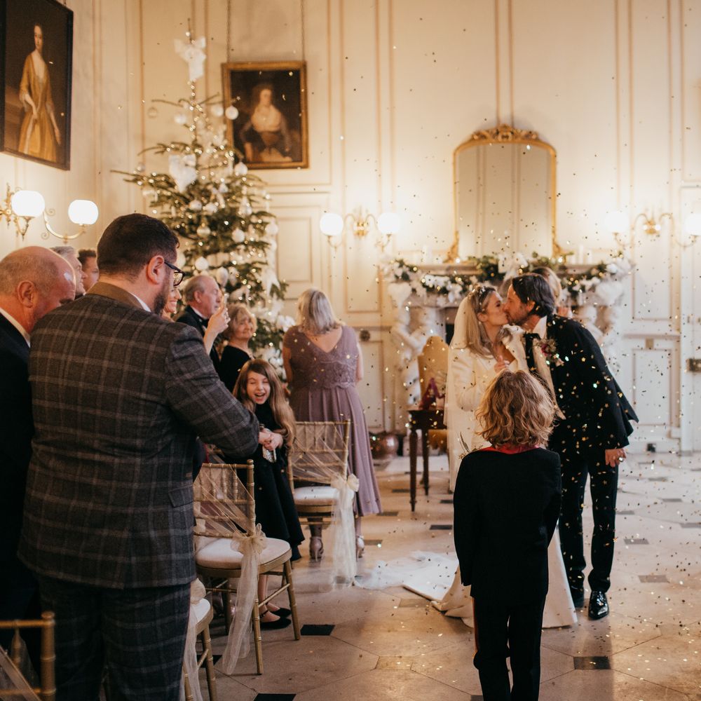 Bride & groom kiss as confetti cannon goes off around them