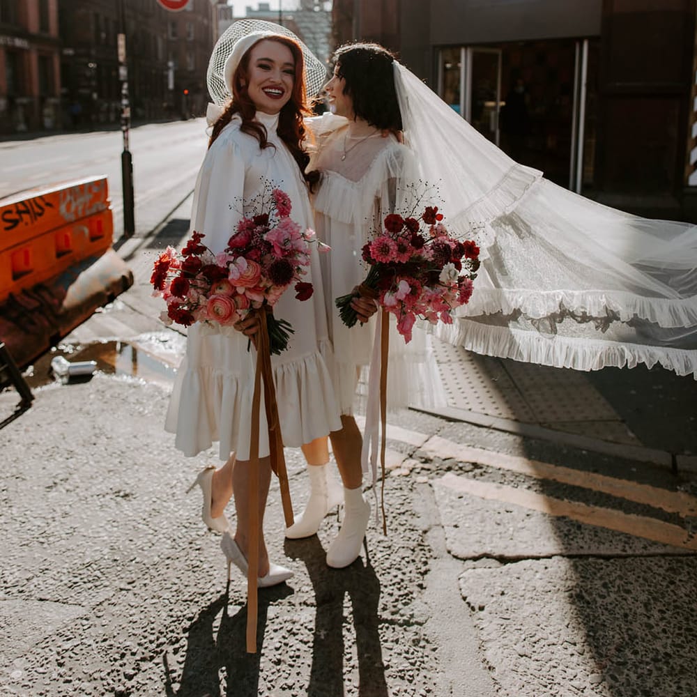 Two brides in Moonchild short wedding dress with long veil and berret at Manchester elopement 