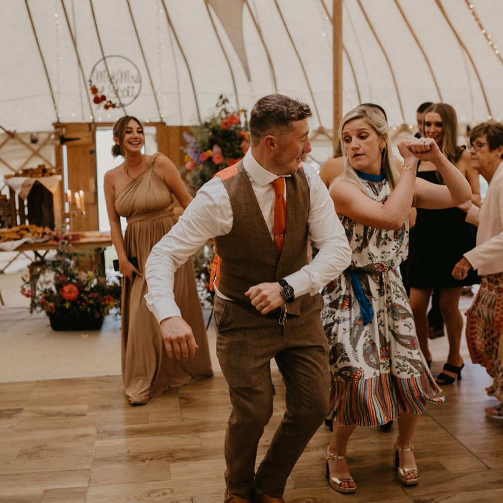Groom dances with wedding guests at wedding reception