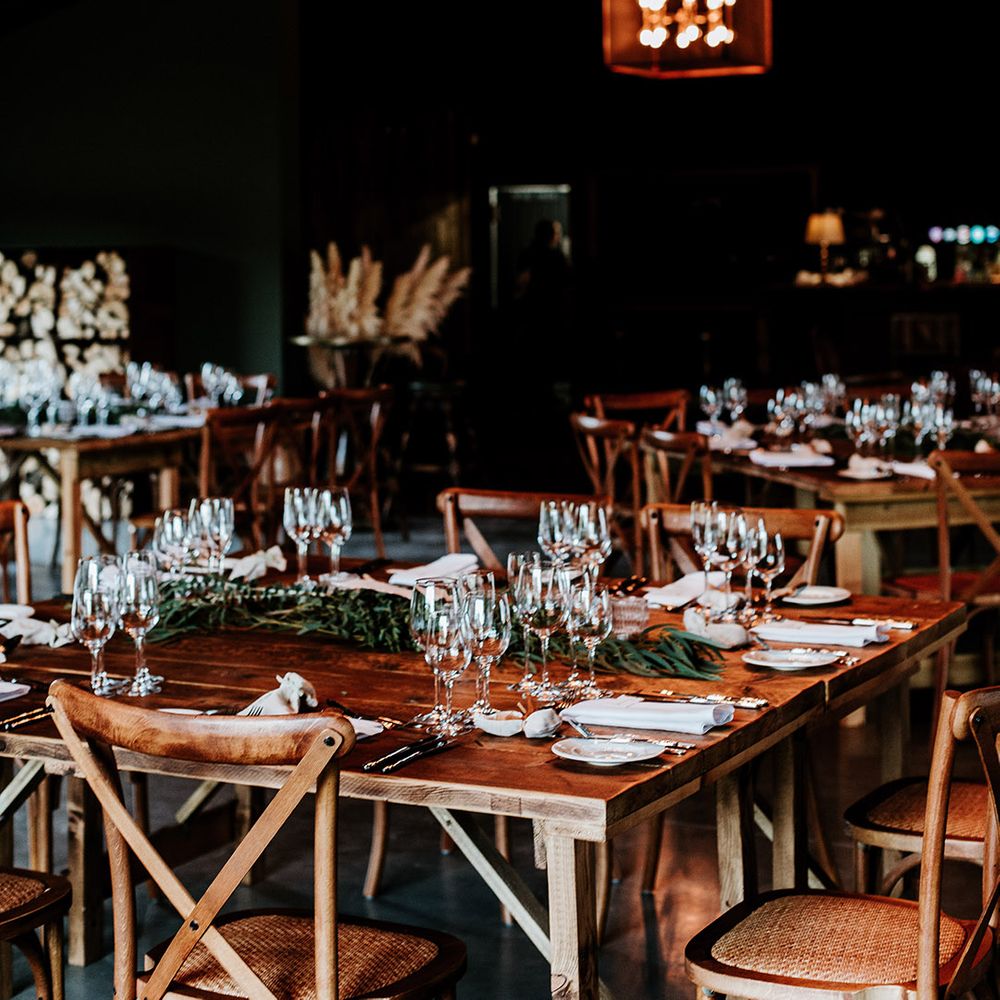 Dark wooden tables with eucalyptus leaves and magical cosy lighting at Silchester Farm wedding venue