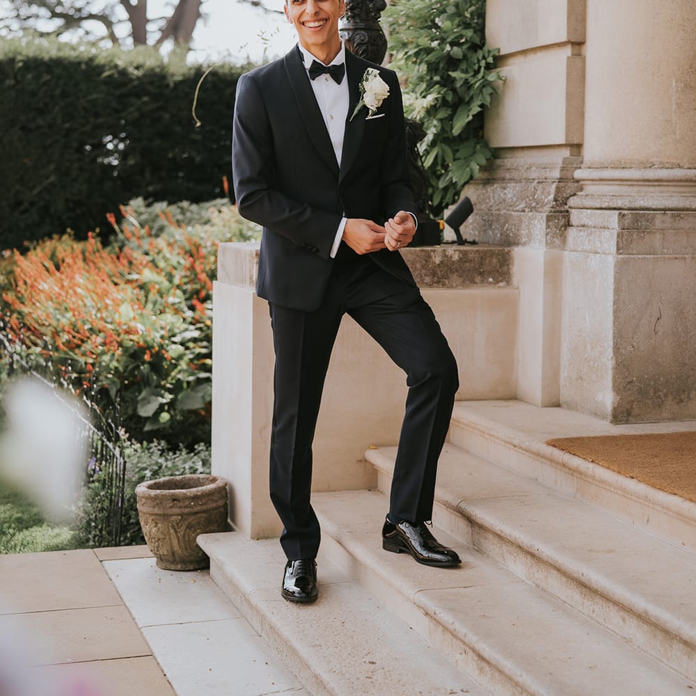 Groom in black tie with white rose buttonhole 