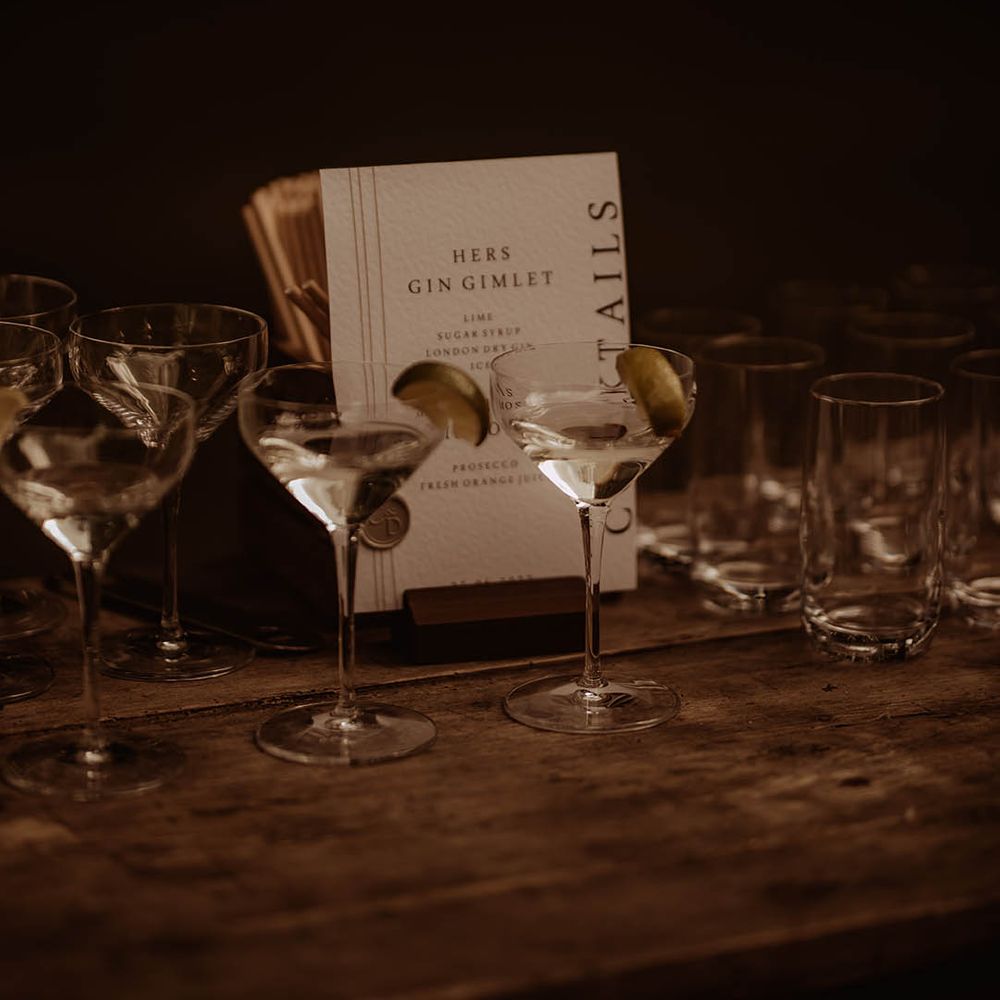 Cocktail hour with different kinds of glasses and cocktail menu card