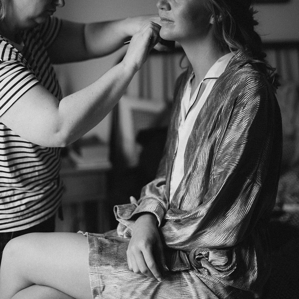 Bride has her makeup done on the morning of her wedding day at Tunnels Beach 