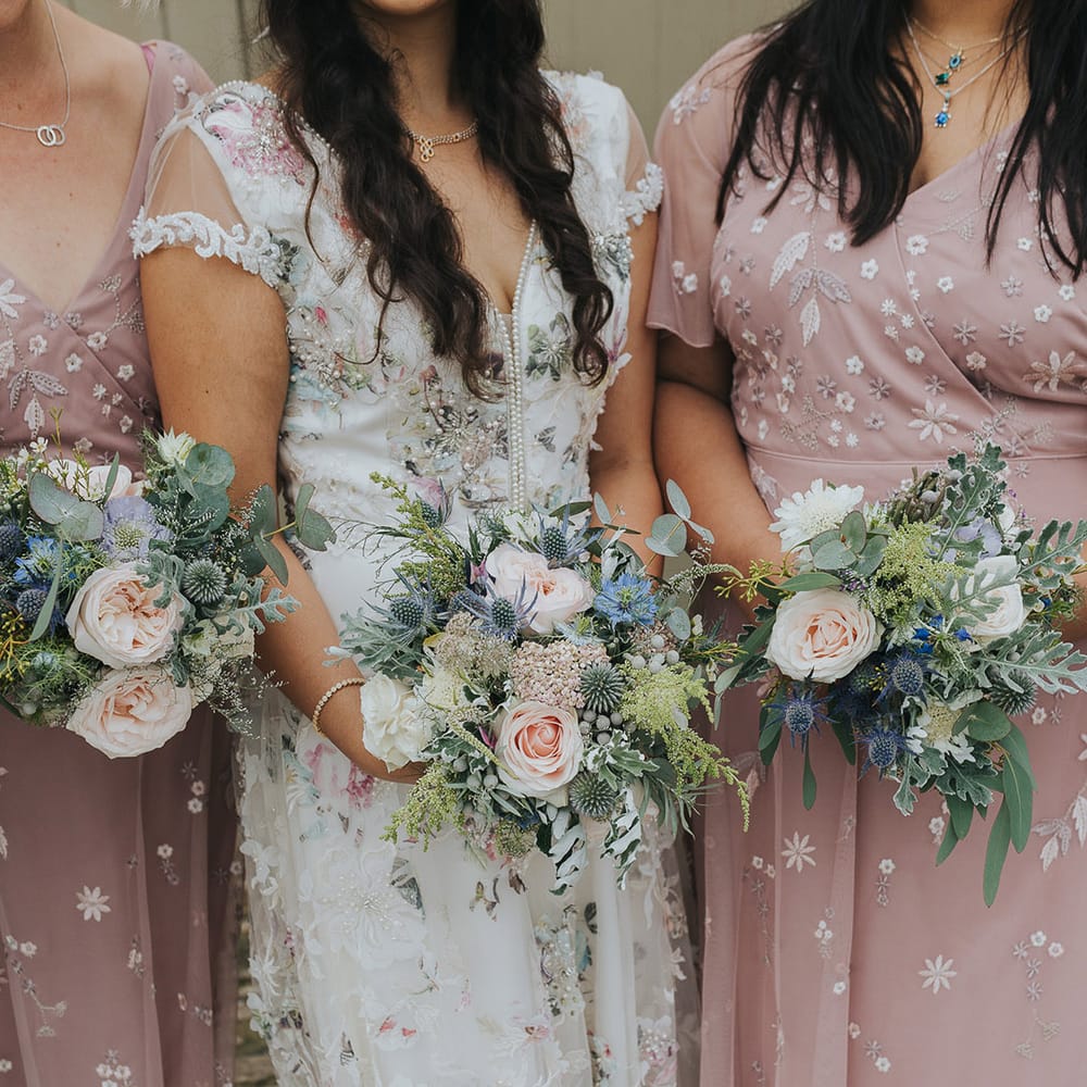 bridal party holding pastel pink and blue wedding bouquets 