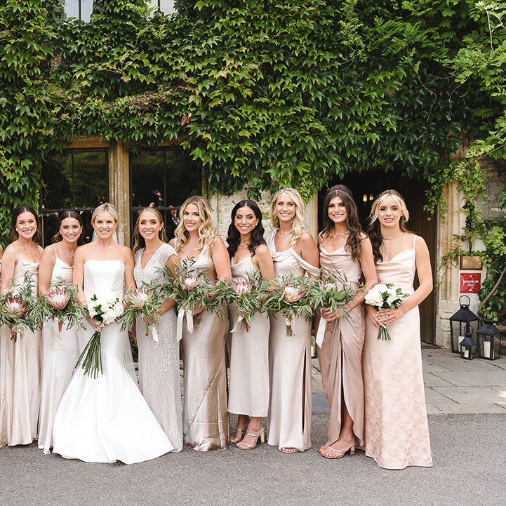 Bridesmaids in mismatched gold bridesmaid dresses with the bride for the traditional wedding 