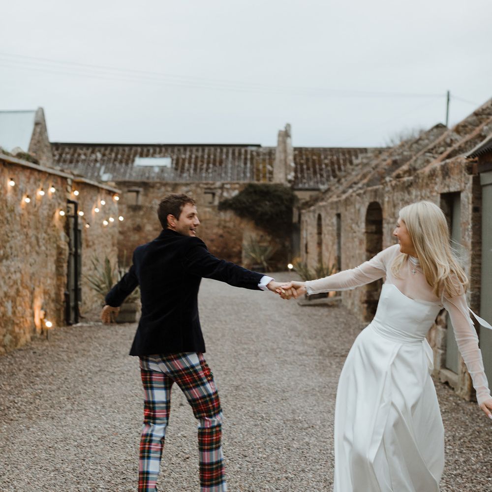 The bride and groom take cute couple portraits together as they dance 
