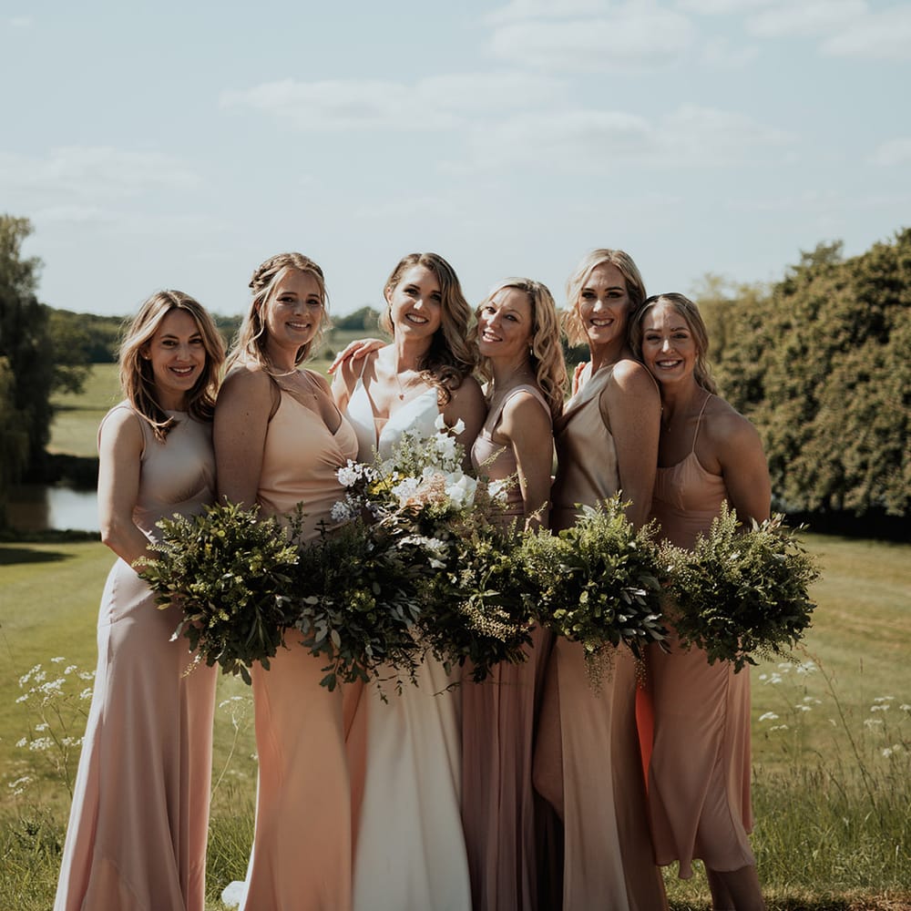 Bridal party posing wit the bride for stunning picture outdoors 