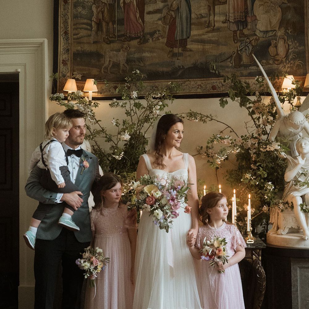The bride and groom stand with their children at their wedding ceremony 