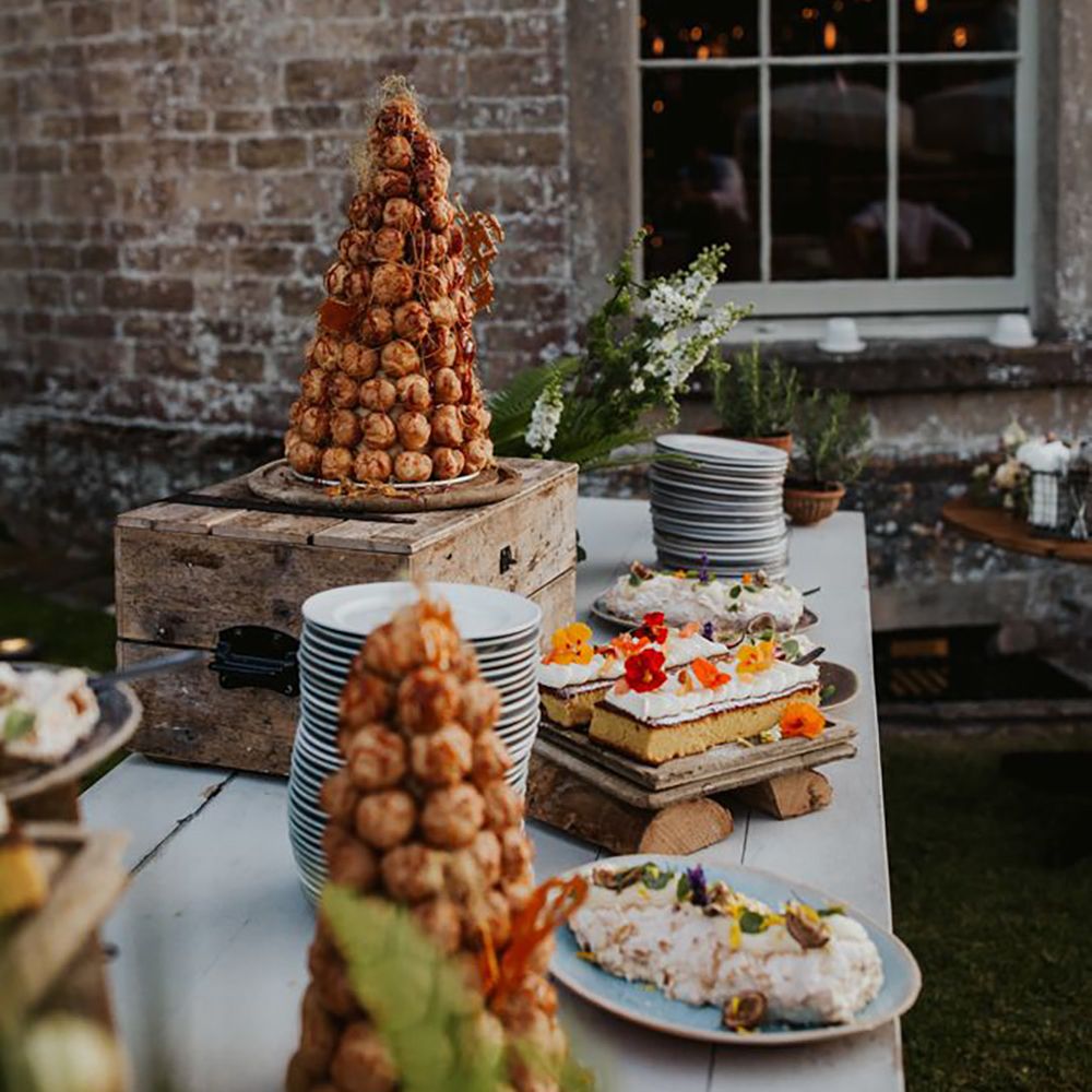 Luxe country house wedding with a dessert table including a croquembouche, pavlova and cake 