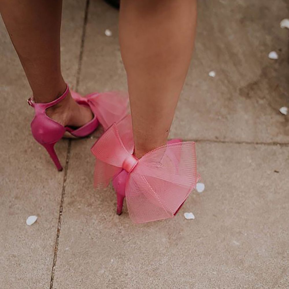Person wearing pink bow heel shoes with oversized mesh bow on the back of the shoes by Georgina Harrison Photography