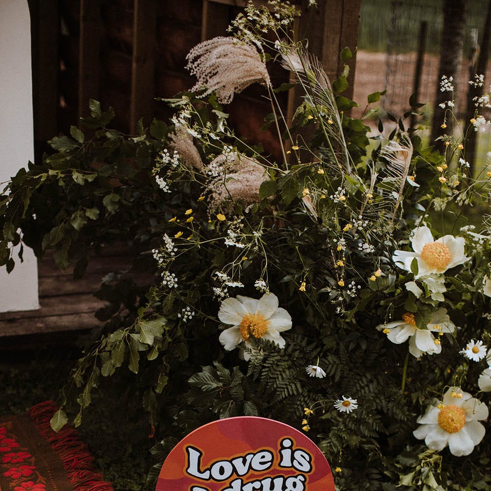 Love is a drug retro wedding sign and wildflowers for sixties wedding 