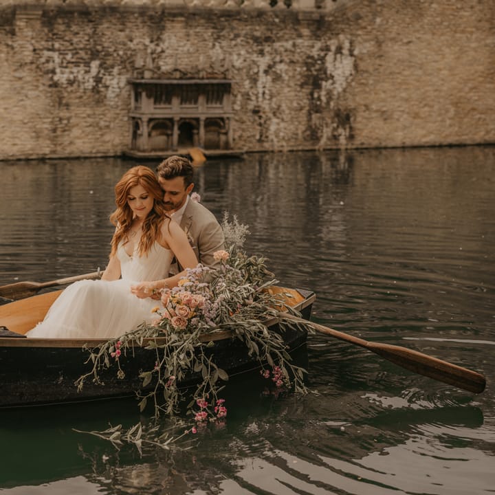 Bride and groom rowing a boat at The Lost Orangery, Euridge Manor