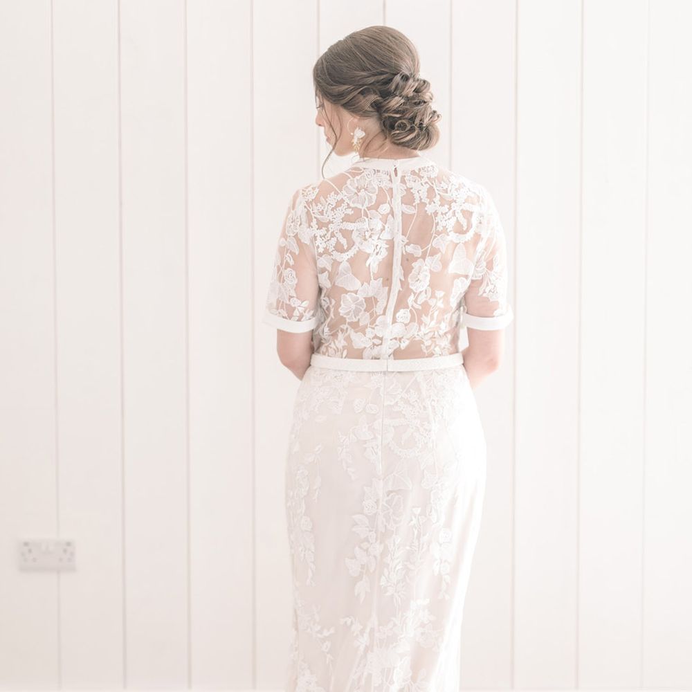 Bride in an appliqué lace Phase Eight wedding dress with short sleeves at The White Barn 