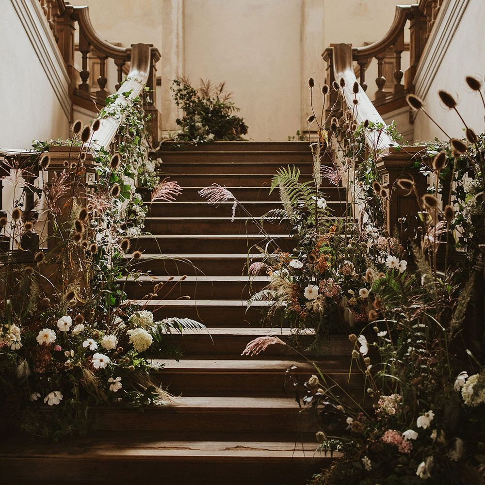 Rustic staircase complete with floral installation throughout bannisters 