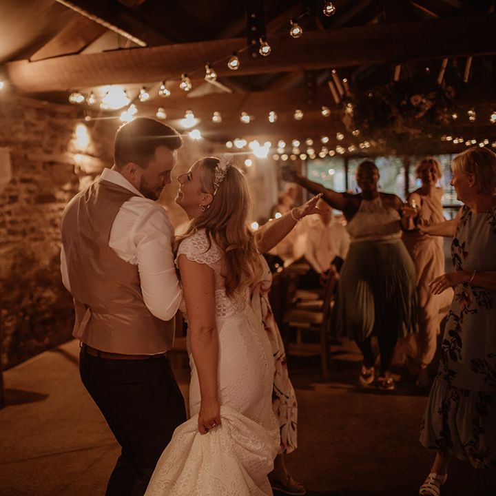 Bride and groom dancing at their Dewsall Court wedding reception with festoon lights 