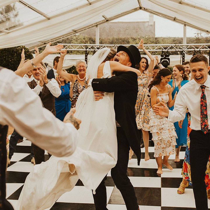 Bride embracing her father after a surprise flash mob dance 