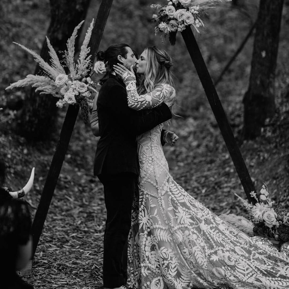 Bride & groom kiss outdoors 