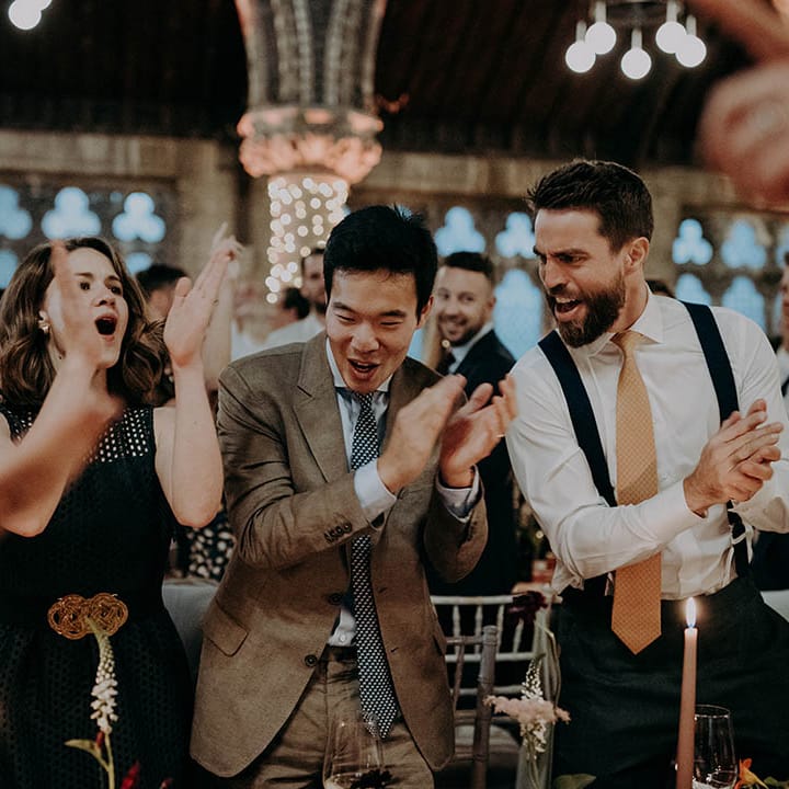 Wedding guests clap and dance during reception