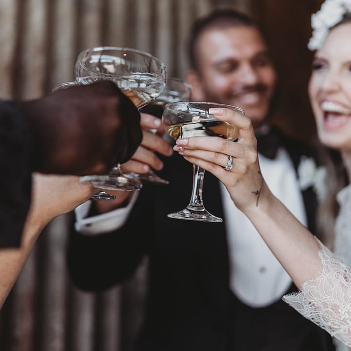 Bride and groom cheers with their wedding party with champagne 