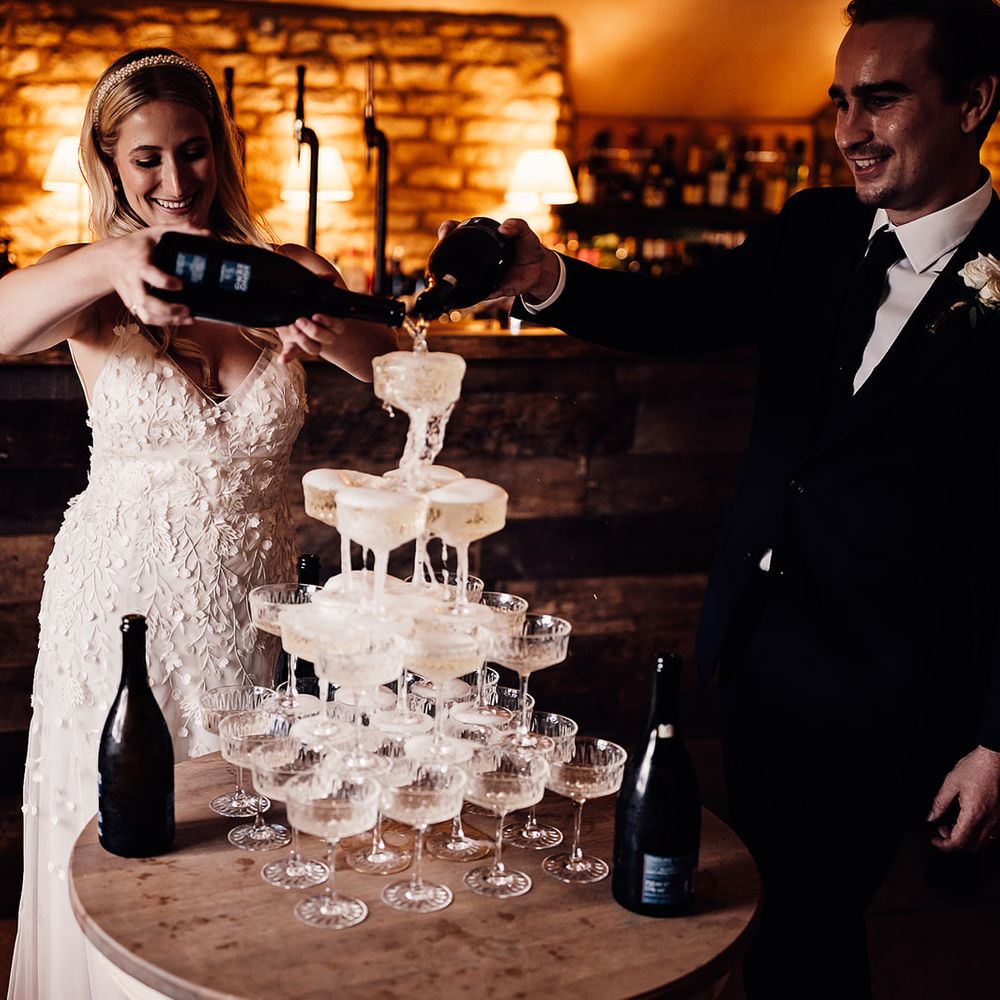 Bride and groom pour Prosecco for a Prosecco tower 