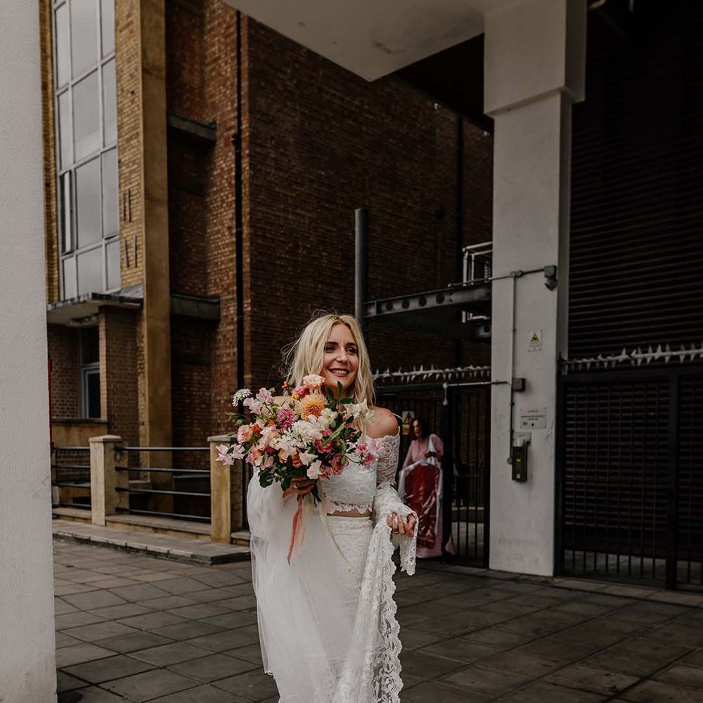 Bride in lace boho two piece and bright mixed floral wedding bouquet