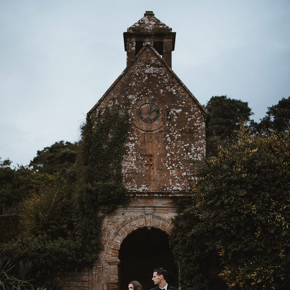 Bride in off the shoulder wedding gown with the groom in a green velvet tuxedo at Brympton House venue 