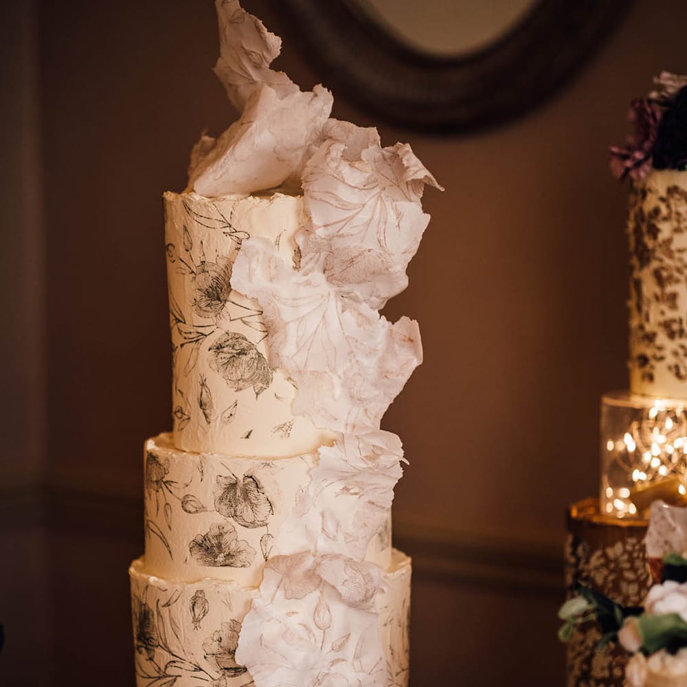 Three tier buttercream frosted wedding cake with black rose decoration and 3D sugar paper decoration 