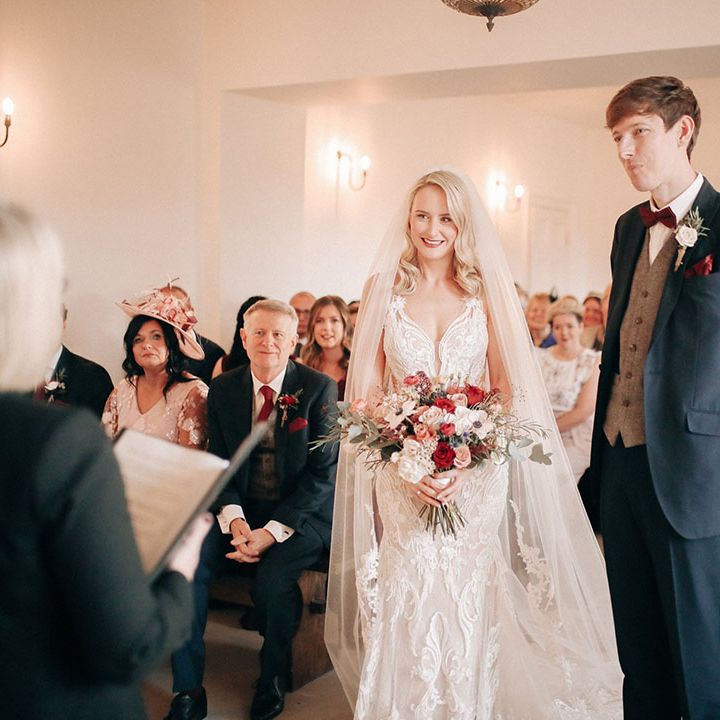 Winter wedding ceremony at Aswarby Rectory with the groom in navy suit with bride in embellished wedding dress and veil 