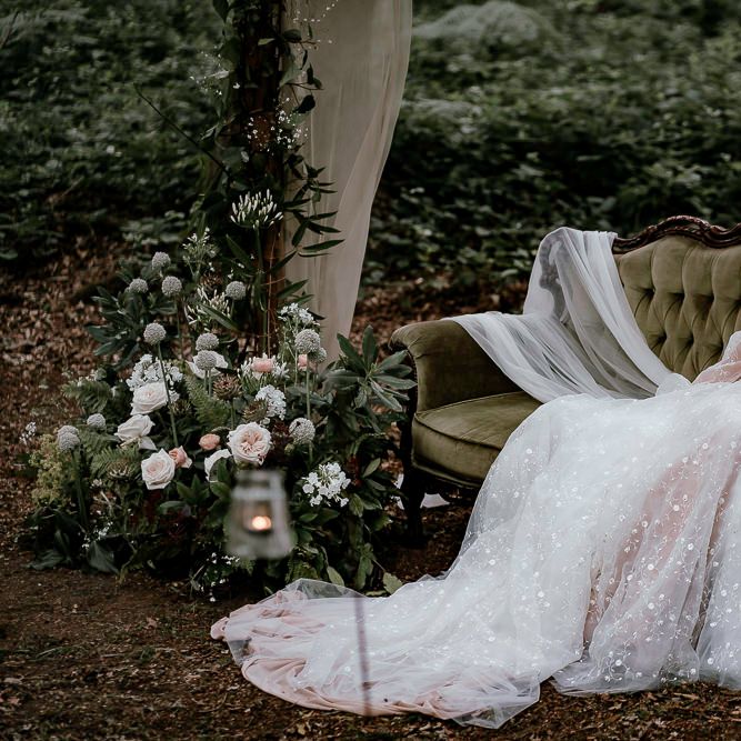 Bride in bespoke wedding dress sitting in the woods 