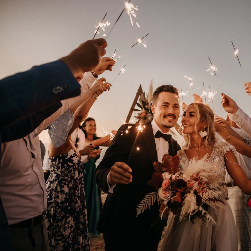 Bride and groom laugh under sparklers