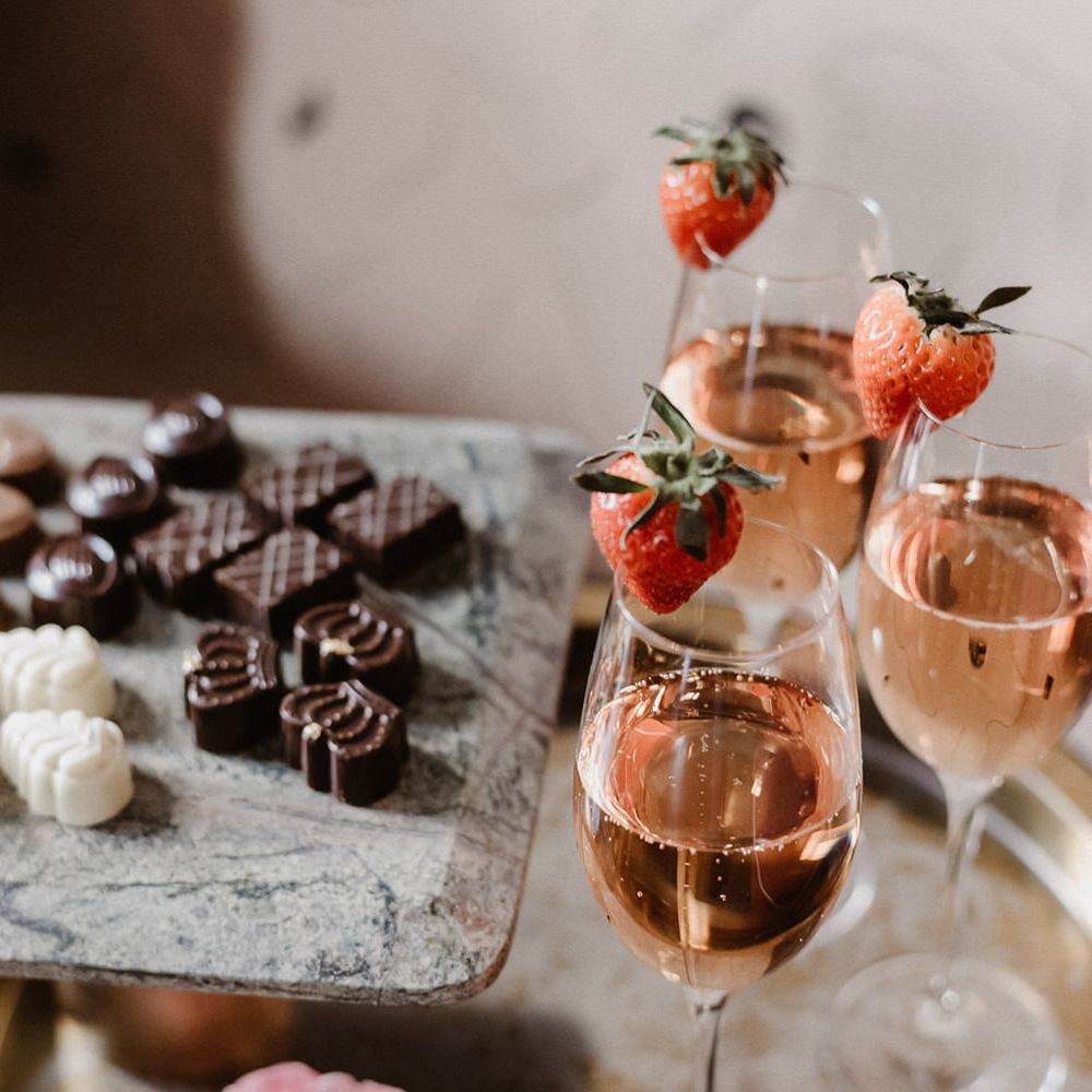 Praline chocolates and blush champagne with a strawberry garnish