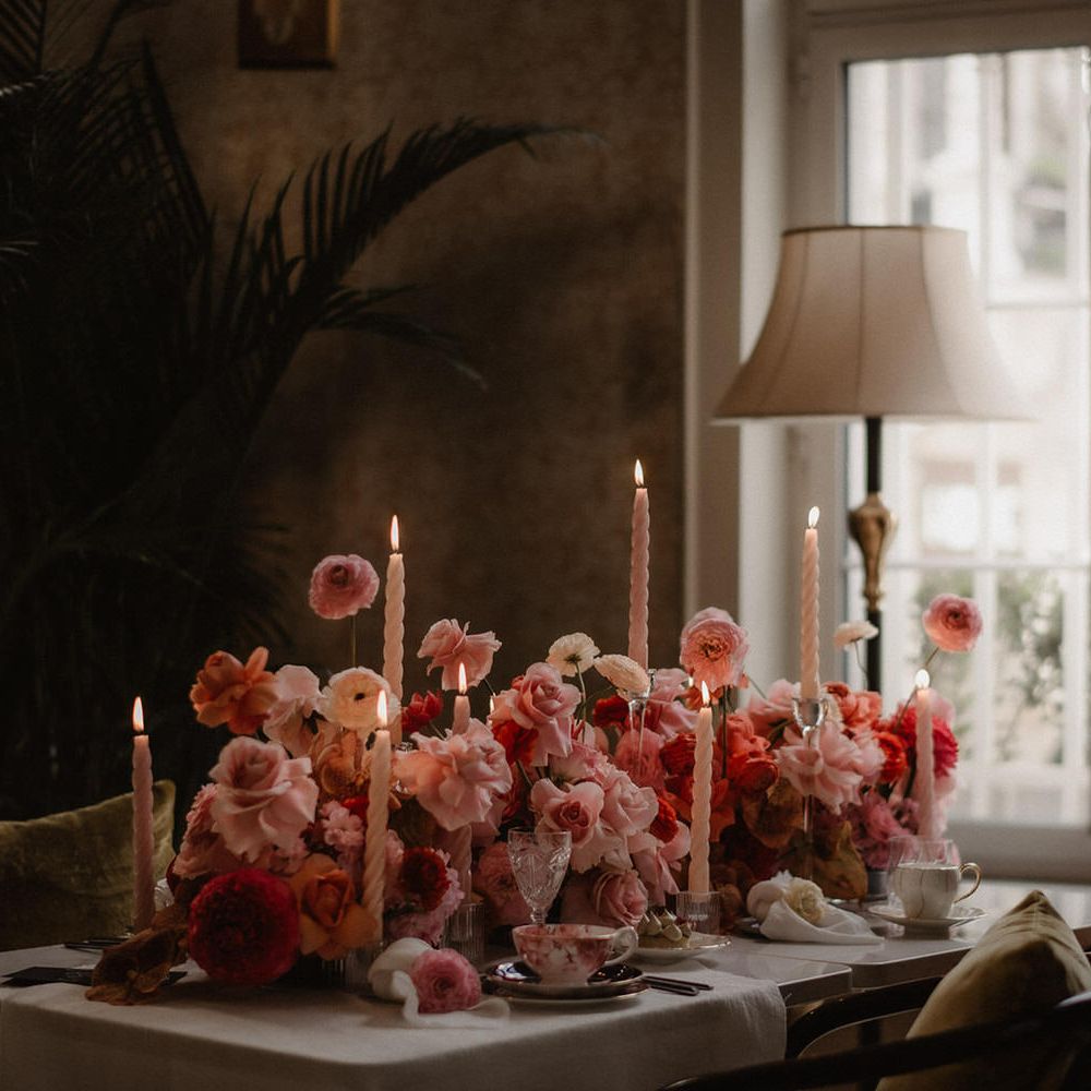 Luxe pink and peach wedding flowers tablescape at Amadria Park Hotel, with tapered candles and palm trees