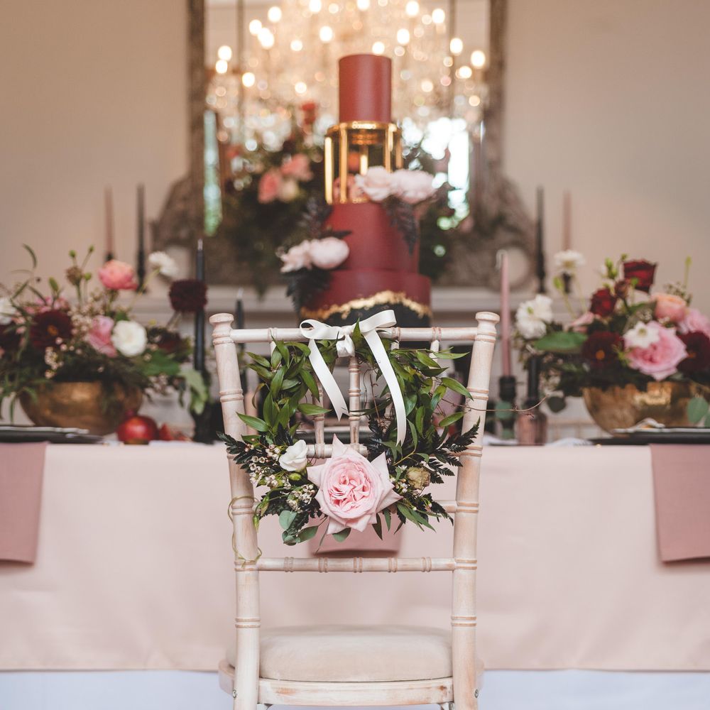 Floral hoop chair back wedding decor with foliage, roses and ribbon 