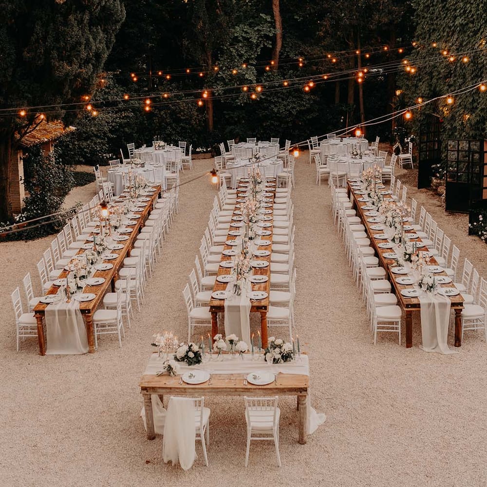 Three wooden tables for outdoor wedding reception complete with fairy light canopy  | Royal Studio